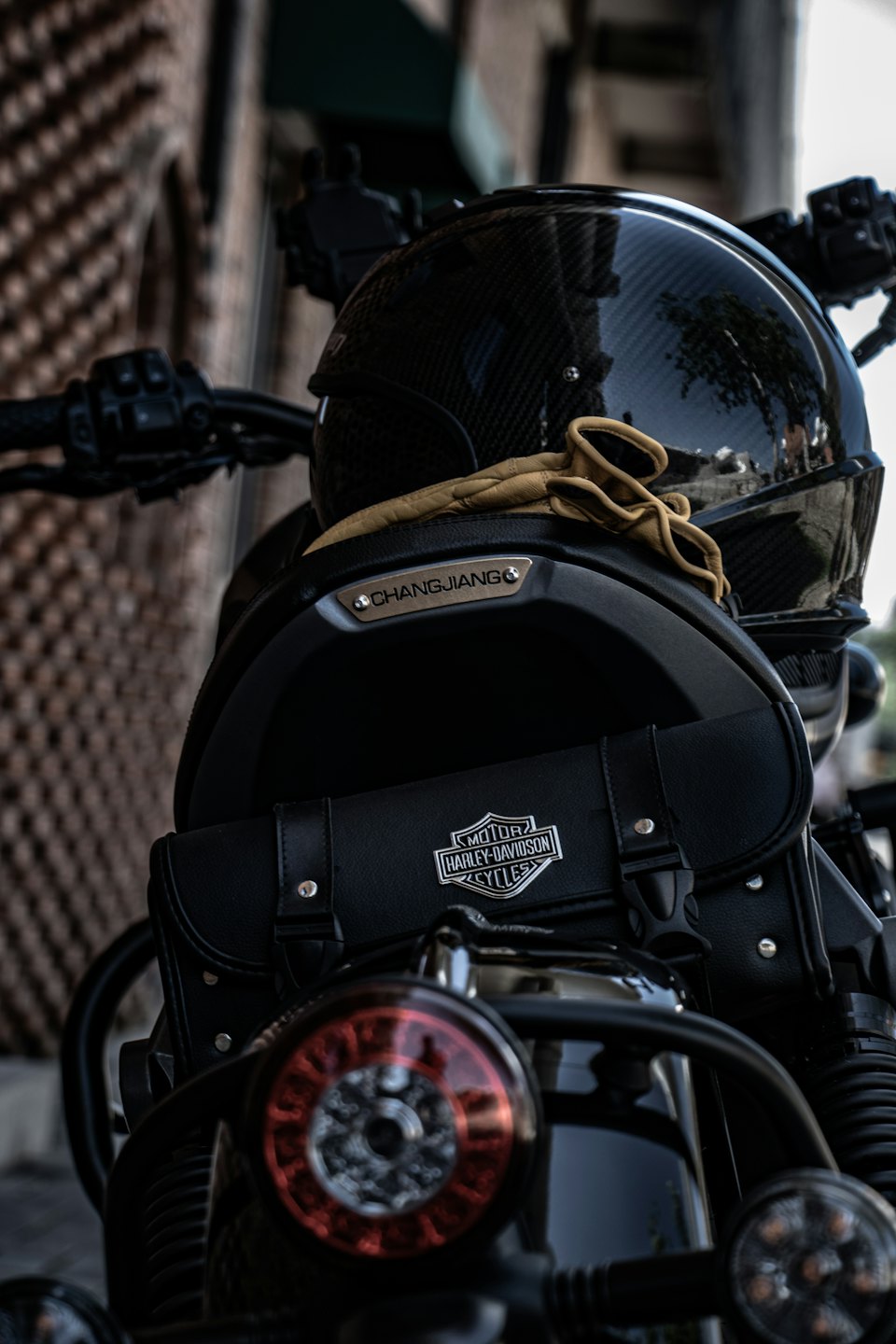 Casco da moto e guanti in pelle appoggiati sul sedile di una moto.
