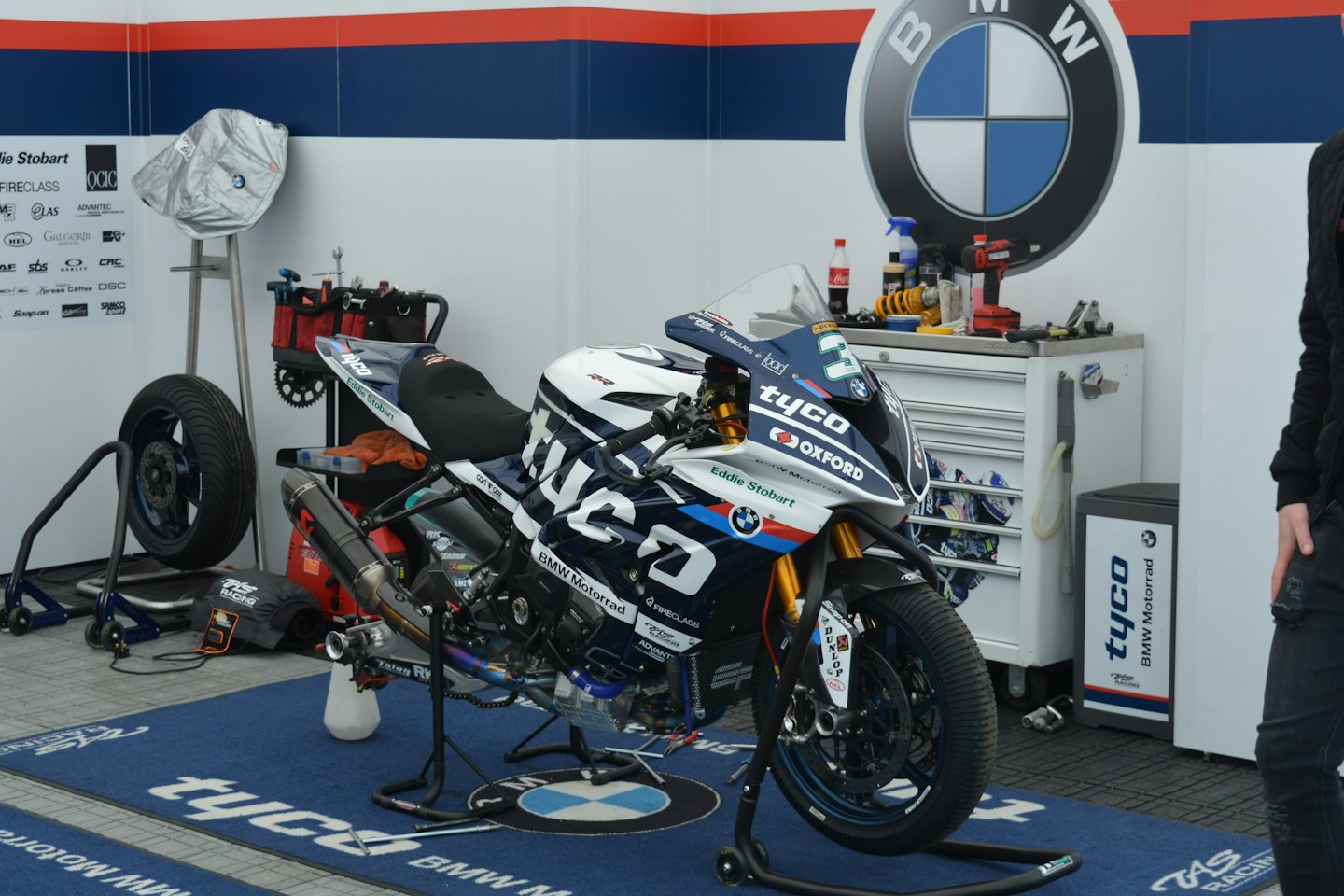 Moto da corsa bianca e blu in un box.